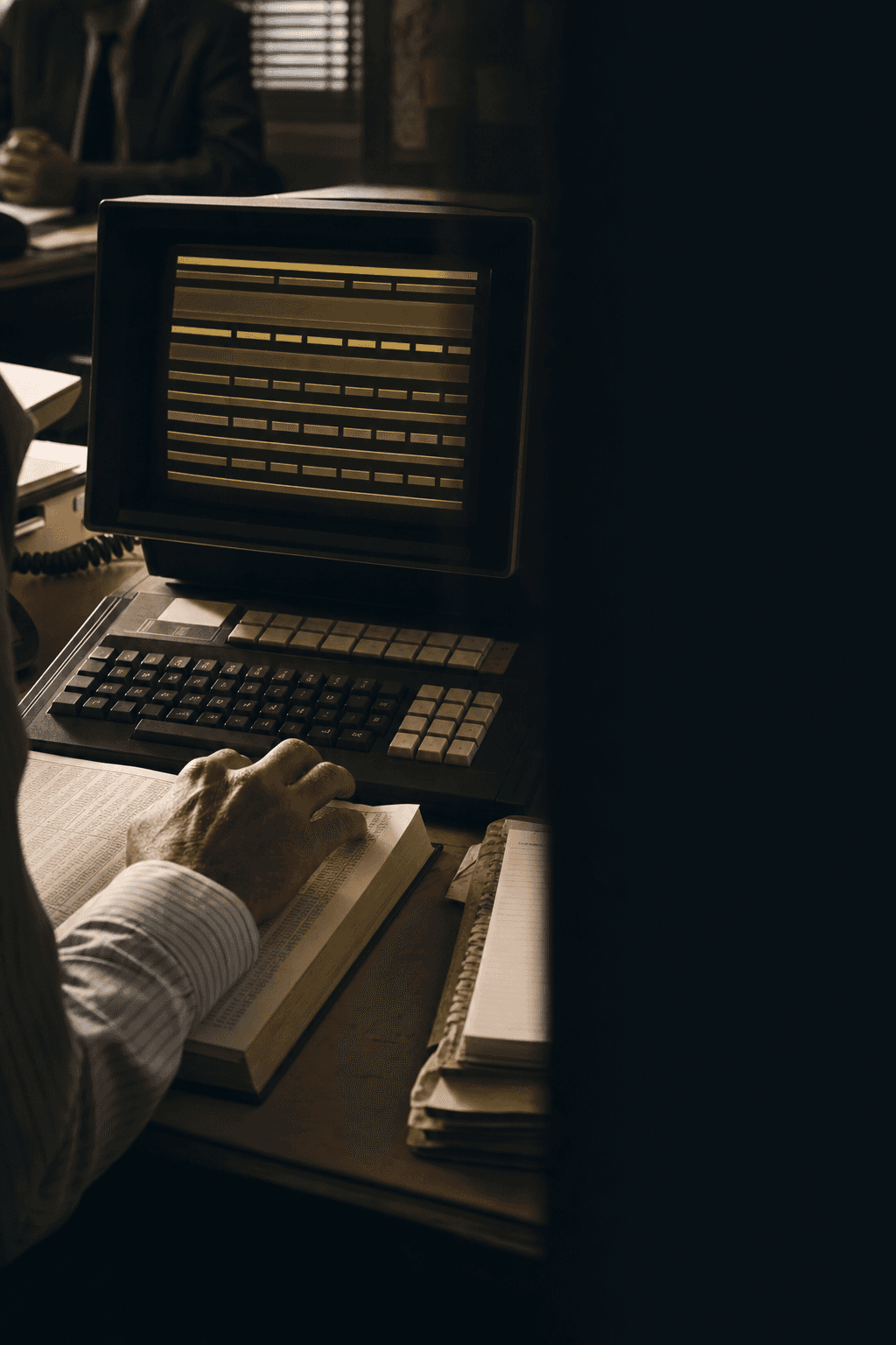 A broker uses a period quotation terminal beside rating books