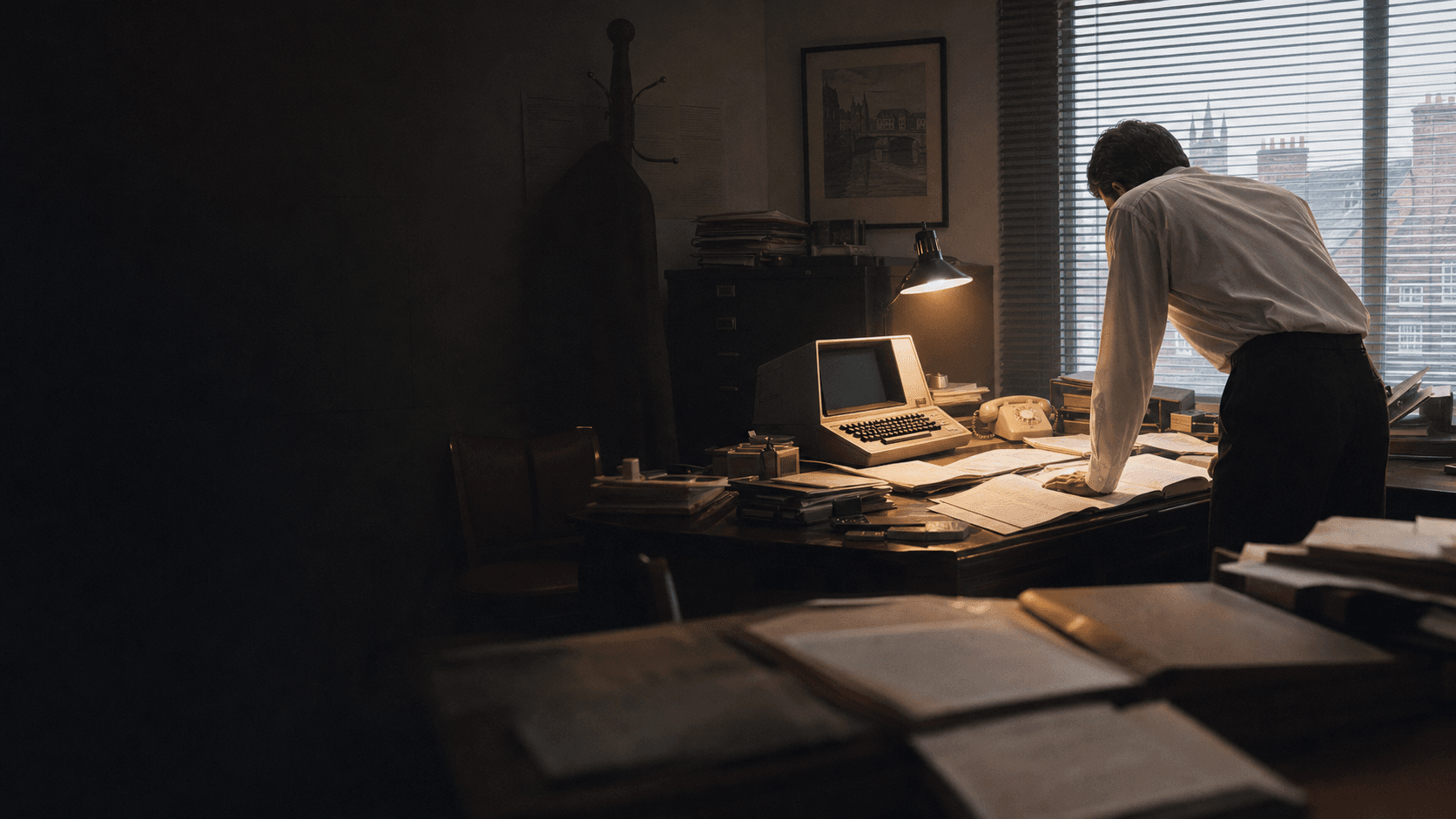 A broker works through policy records beside an early computer terminal